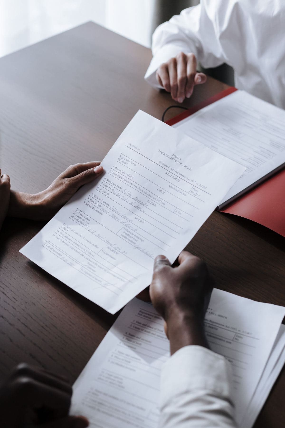 Pessoas revisando documentos jurídicos sobre uma mesa de madeira