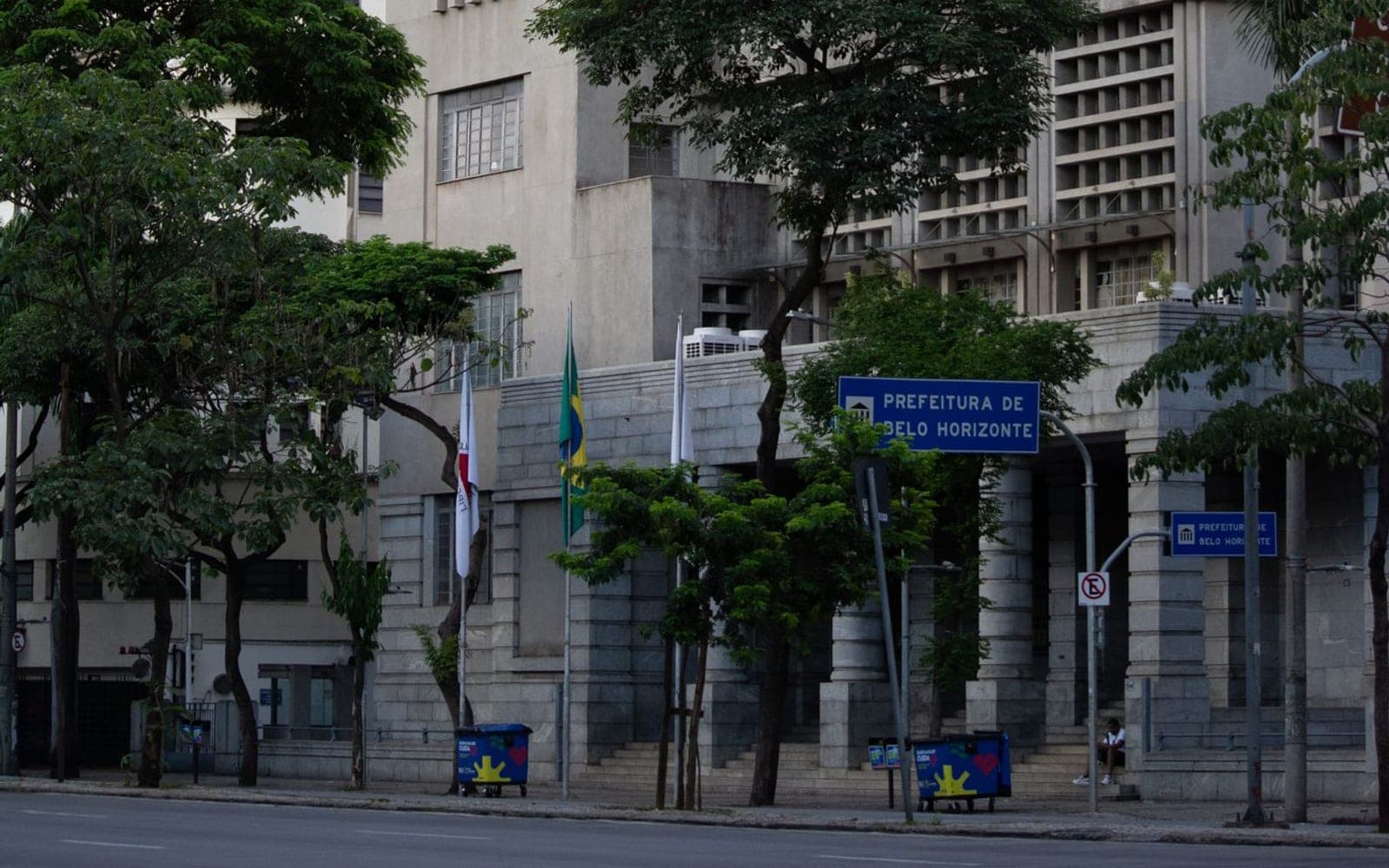 Fachada da sede da Prefeitura de Belo Horizonte, com a placa institucional e bandeiras