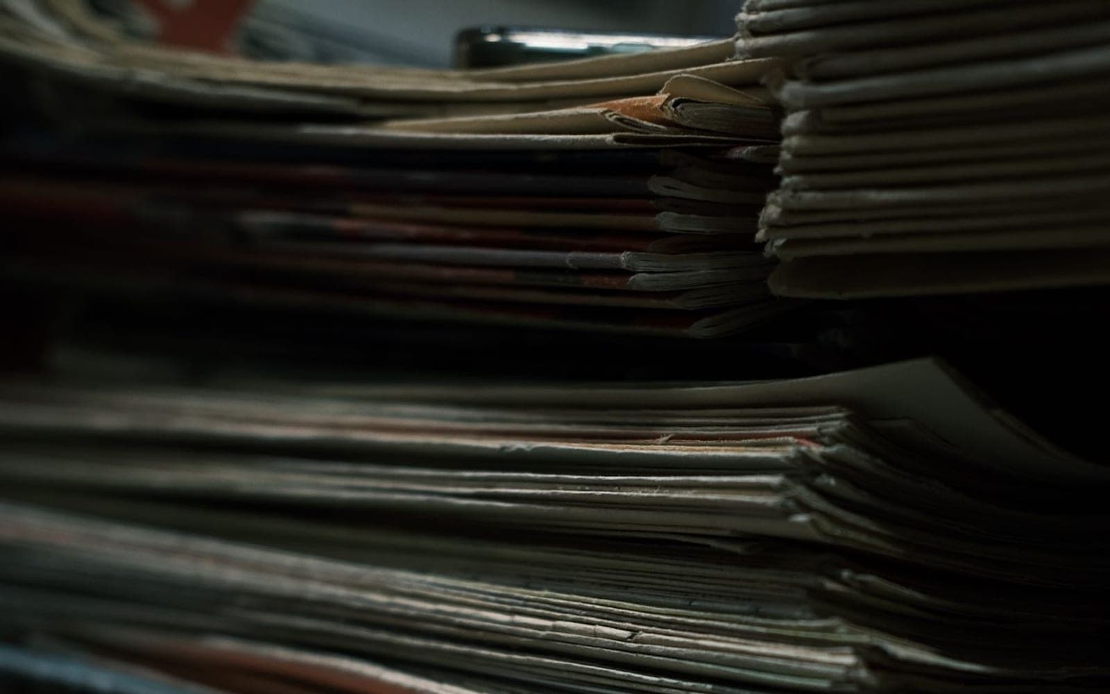 Pilha de documentos antigos em ambiente de pouca luz