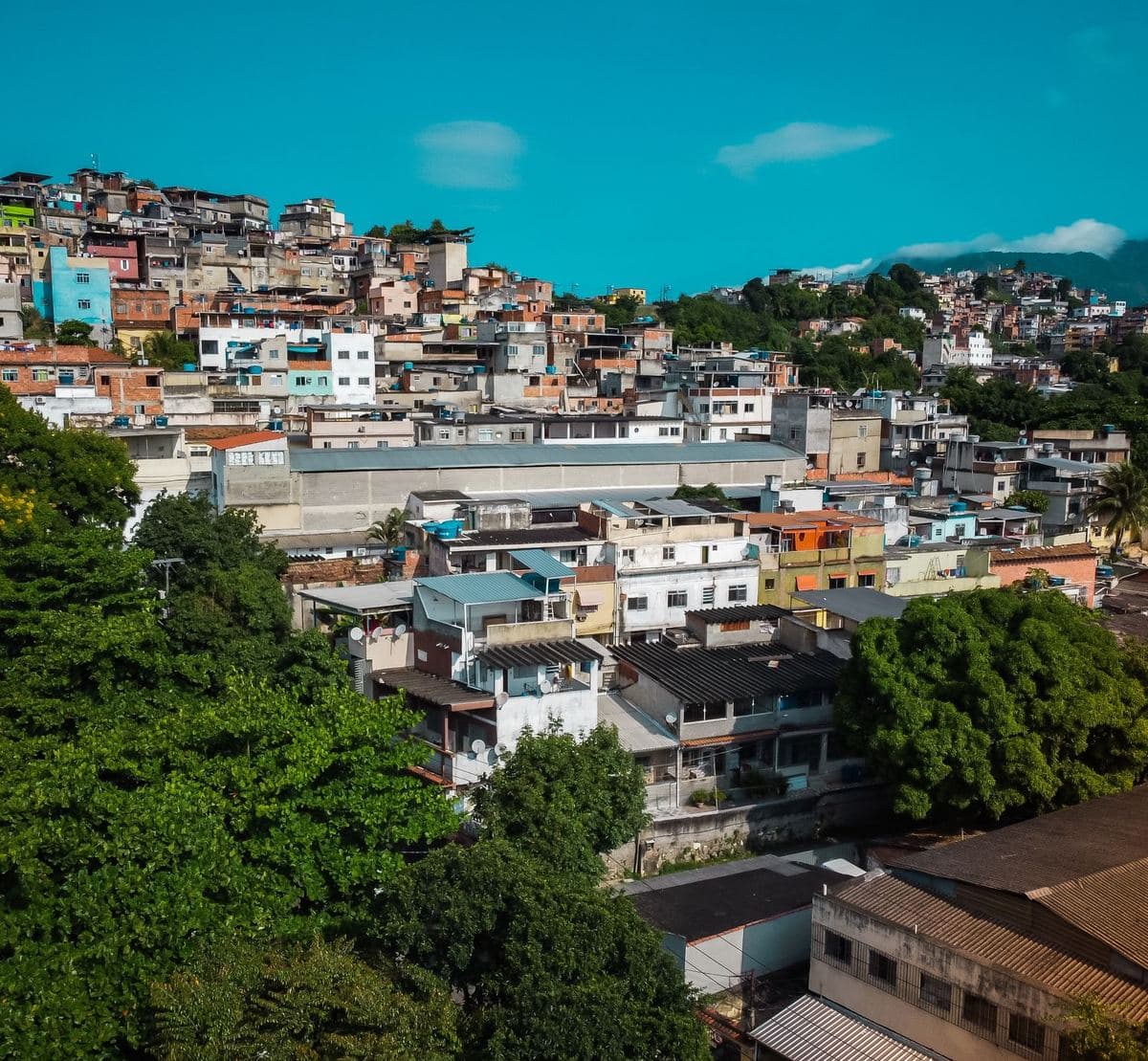 Vista aérea de bairro com ocupação densa e casas coloridas, típico de núcleo urbano informal